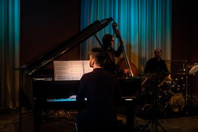 Jazztrio mit Klavier, Bass, Schlagzeug in B&uuml;hnenbeleuchtung | Copyright: Christin K&uuml;ster