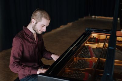 Marius Moritz spielt konzentriert auf einem Fl&uuml;gel, dessen Mechanik mit H&auml;mmern und Saiten sichtbar ist. | Copyright: Thomas Sasse